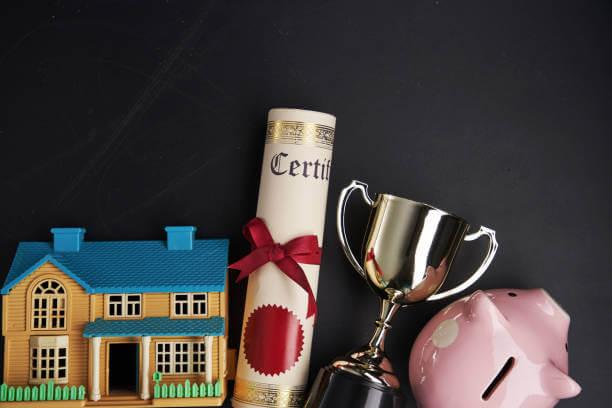 photo of a trophy, a certificate, a house and a piggy bank