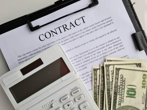 a calculator and money on a contract