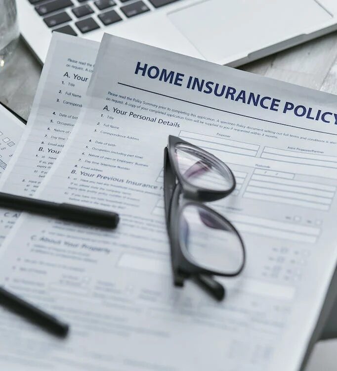 home insurance policy papers with a glasses on it