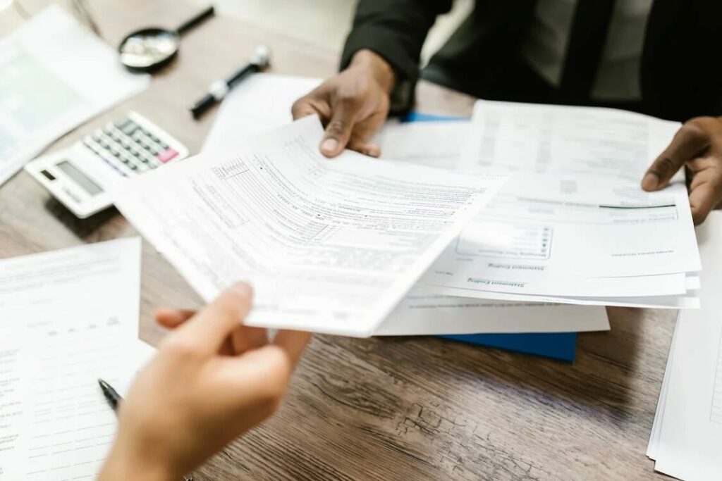image of a person's hand handing a paper to another person