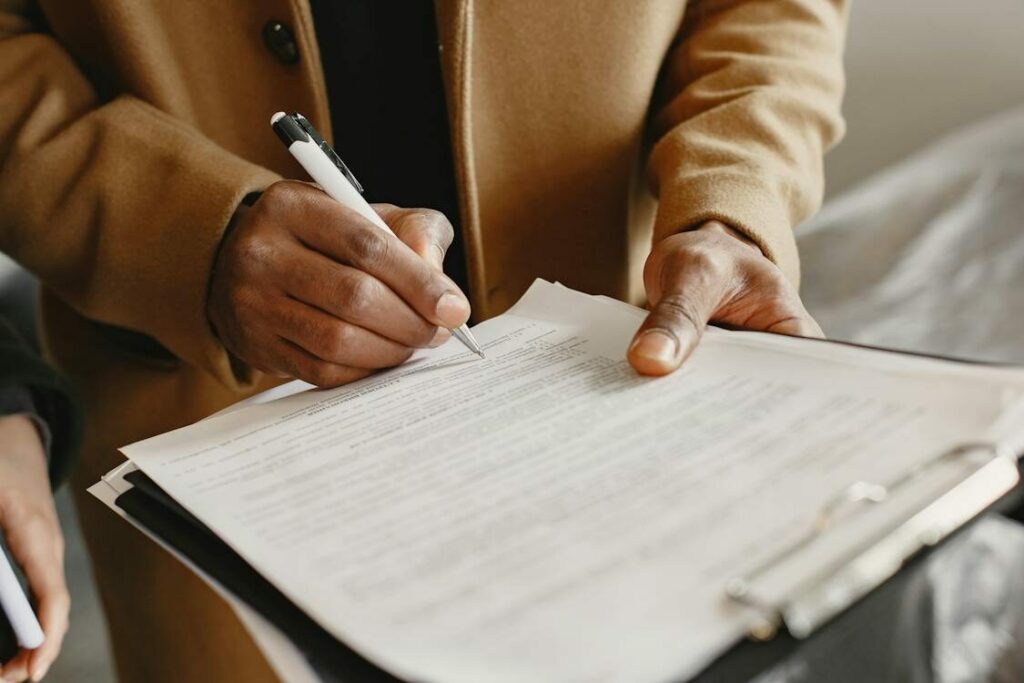 image of a person holding a document while signing it